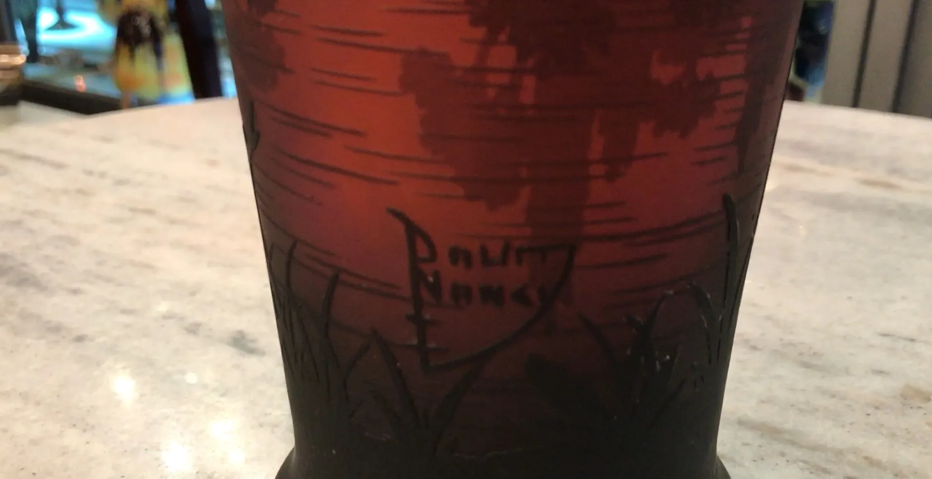 Verre signé ancien avec des détails sombres et un design naturel.