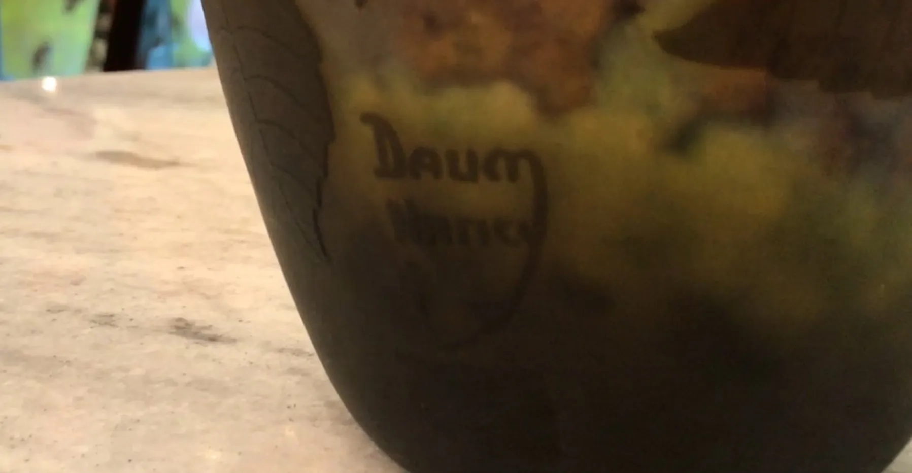 Antikes signiertes Glas Daum Nancy mit sichtbarer Unterschrift, warme Atmosphäre.