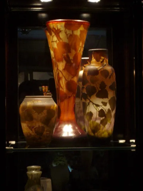 三个带有温暖色调叶子图案的装饰性古董花瓶