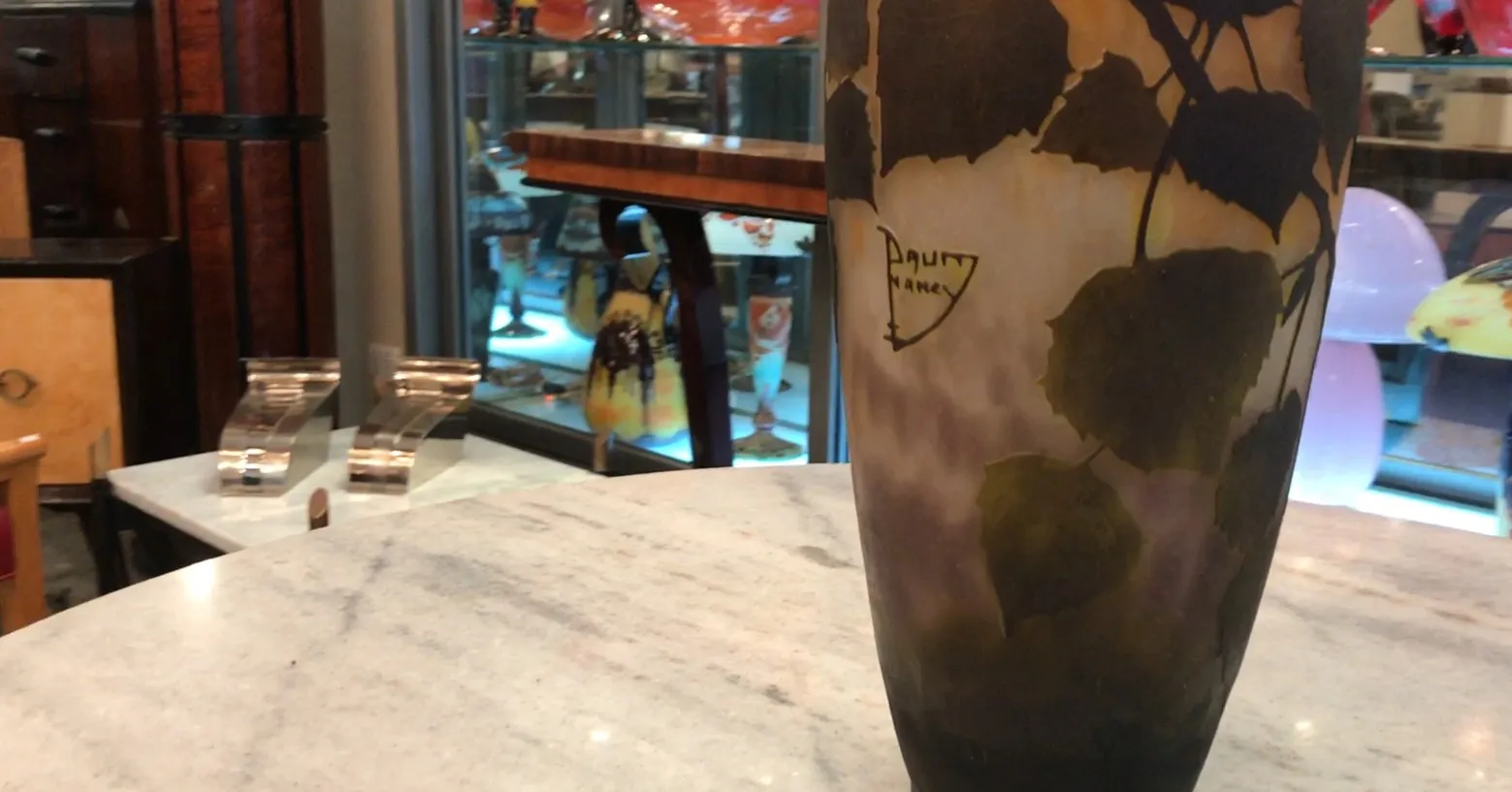 signiertes Glas Daum Nancy mit Blättermotiv in einem alten Ambiente.