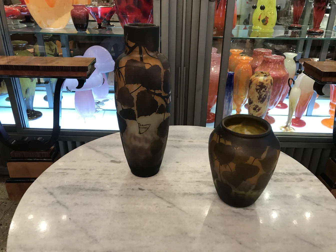 Vaso antico firmato Daum Nancy con design floreale, colore scuro, esposto in vetrina