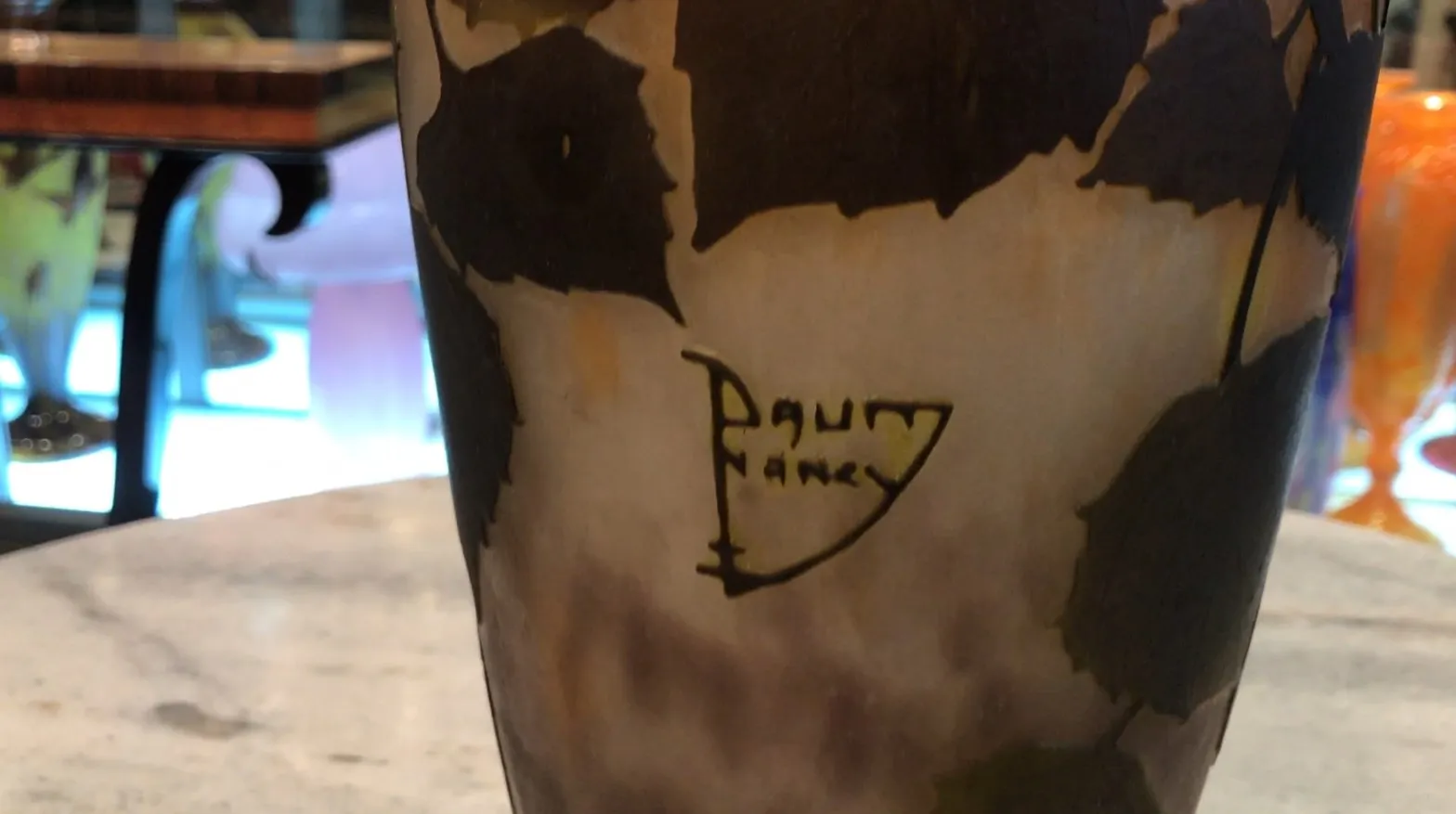 Античное подписанное стекло Daum Nancy с ярким дизайном на размытой заднем плане, идеально для коллекционеров.