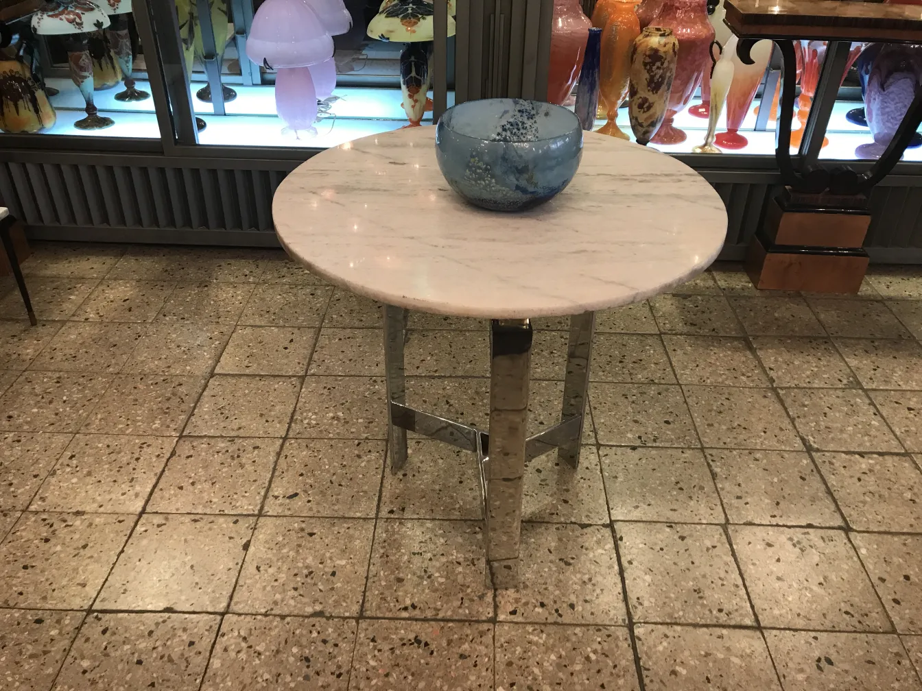 圆形大理石桌子和一个蓝色玻璃碗，背景是古董