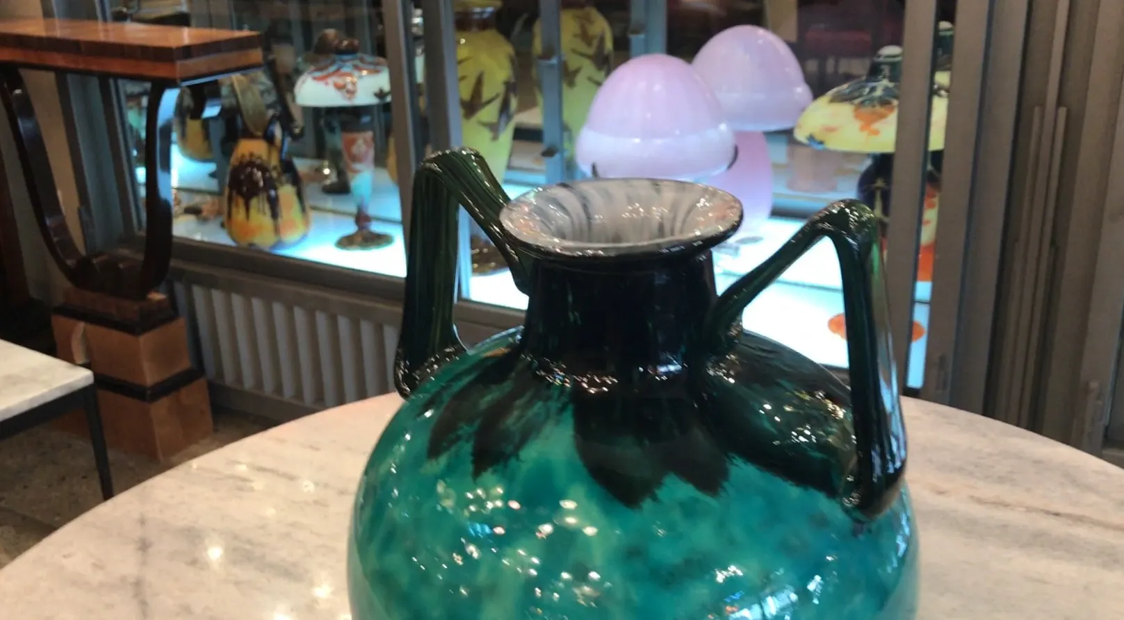 Verre signé Daum Nancy, couleur verte avec poignées, décoré de détails visuels clairs, dans un cadre d'antiquités.