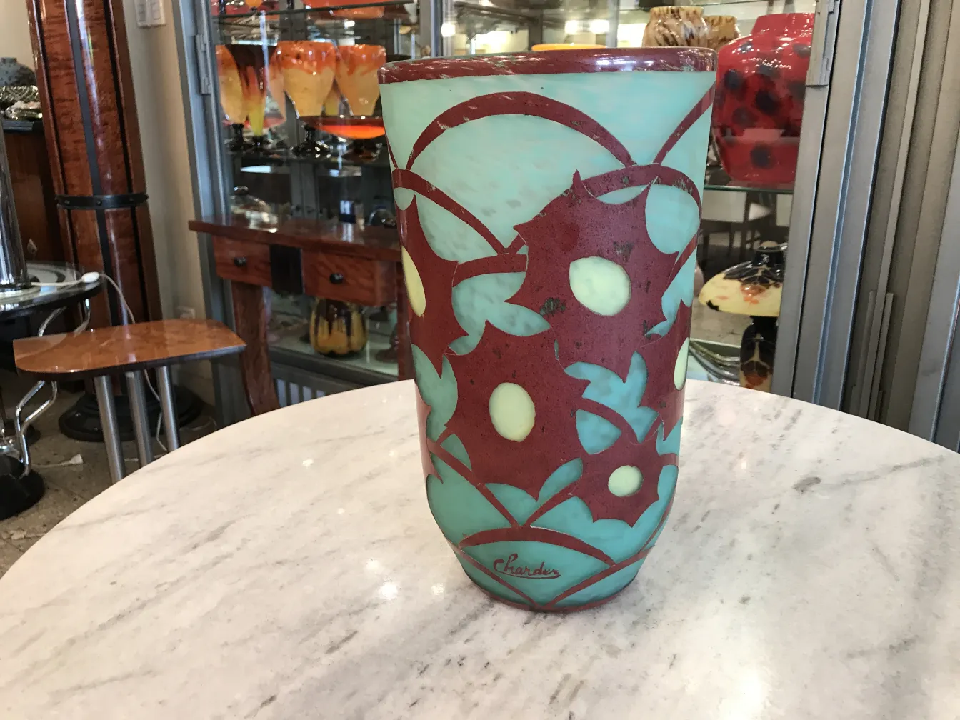 Verre ancien signé Charder avec un design floral arrondi.