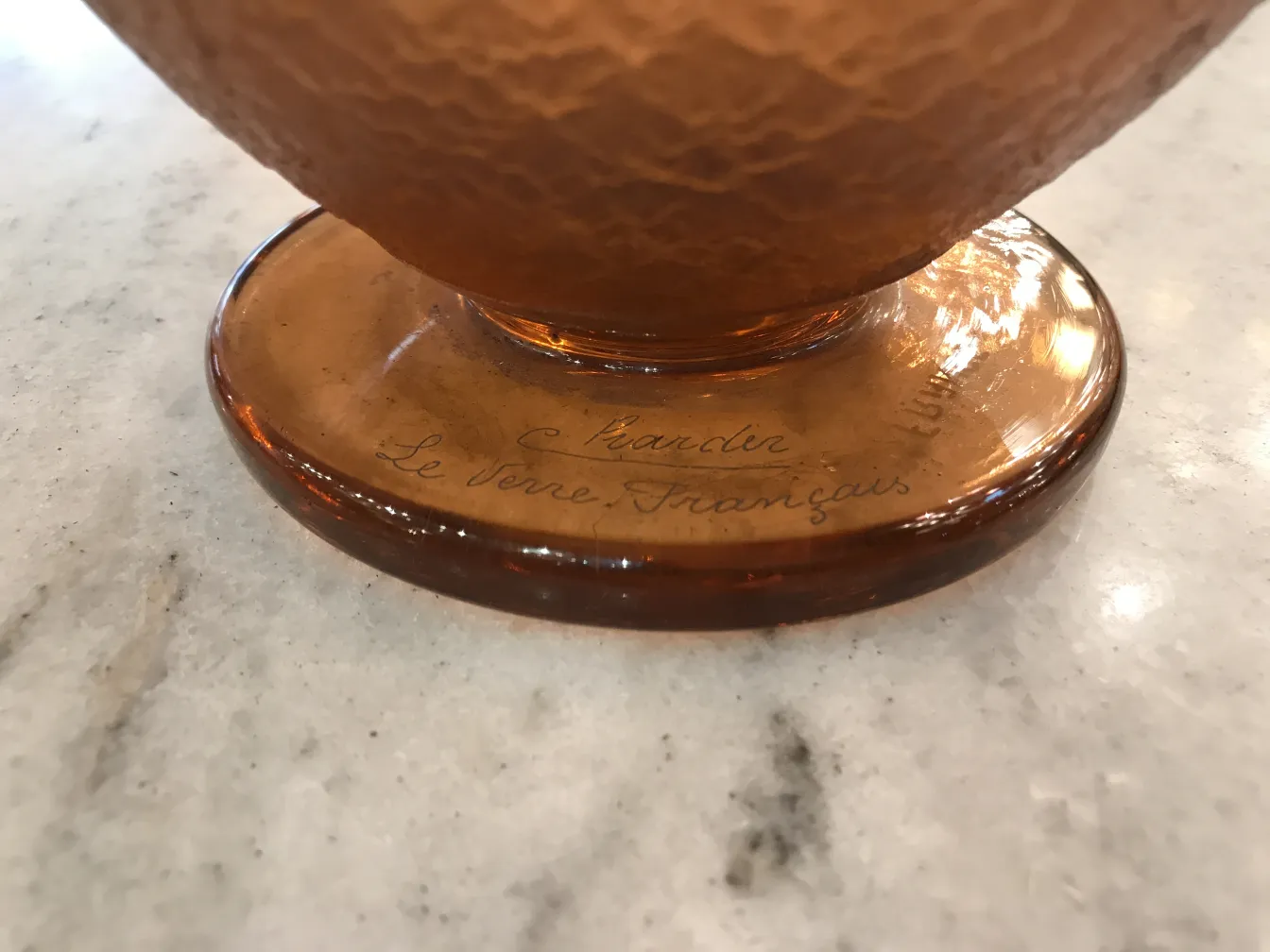 signed glass Charder with a clear, smooth base, in an elegant setting