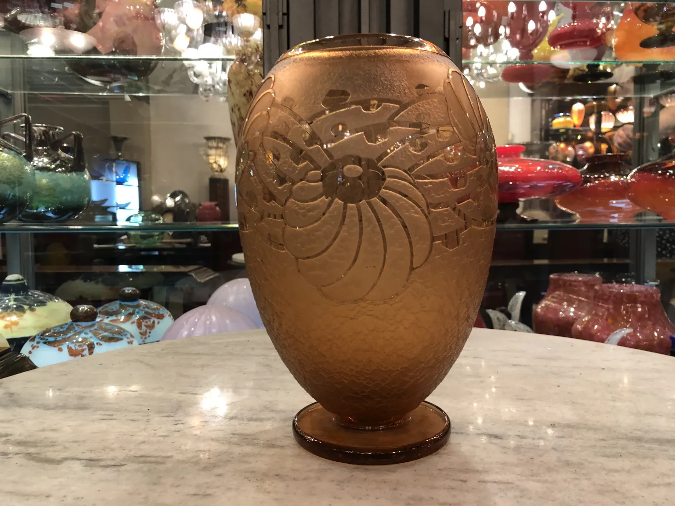 SIGNED GLASS Charder with intricate design and oval shape, displayed in an antique shop.