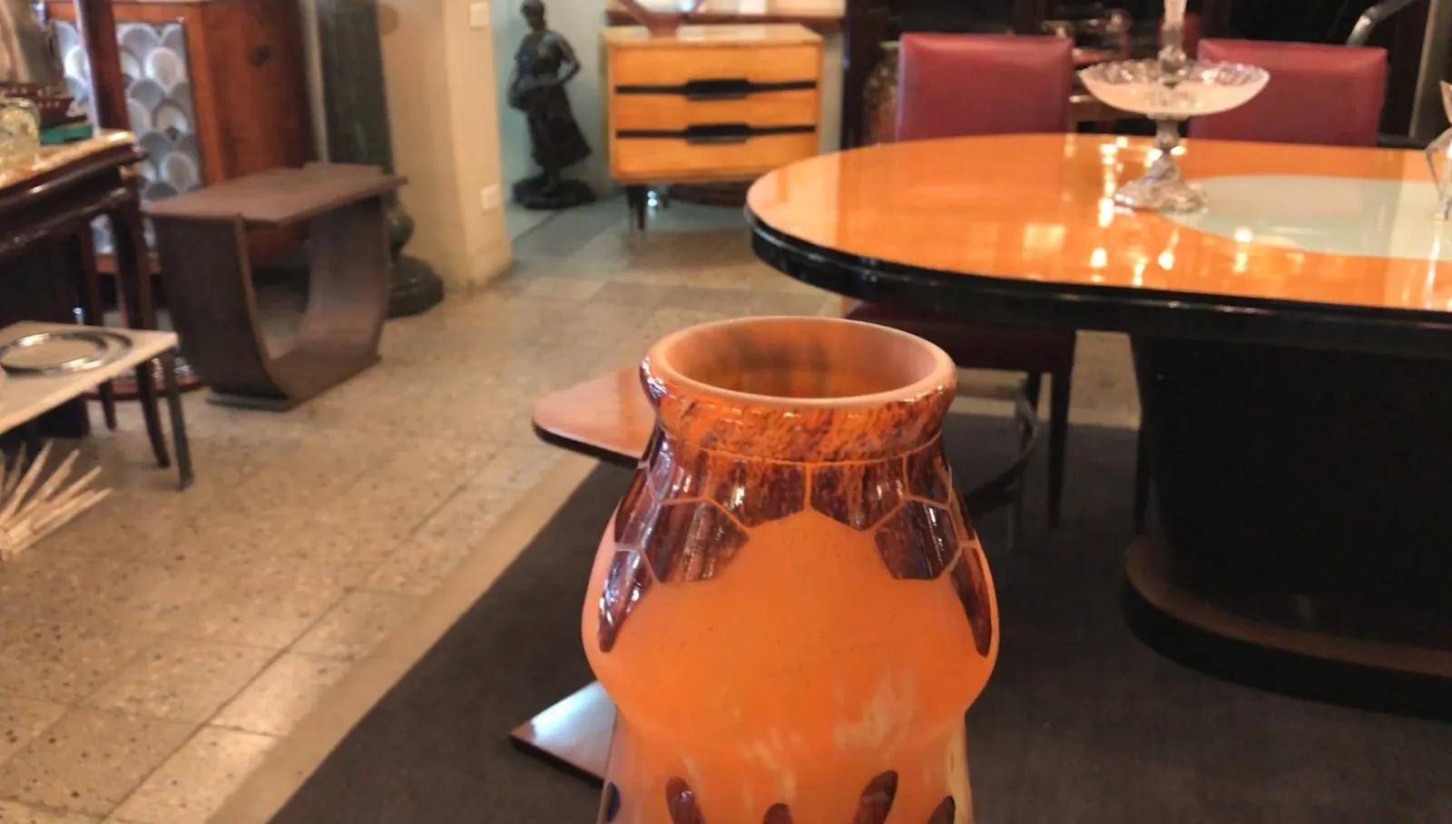 Vidro assinado Charder laranja com detalhes decorativos, colocado sobre uma mesa.