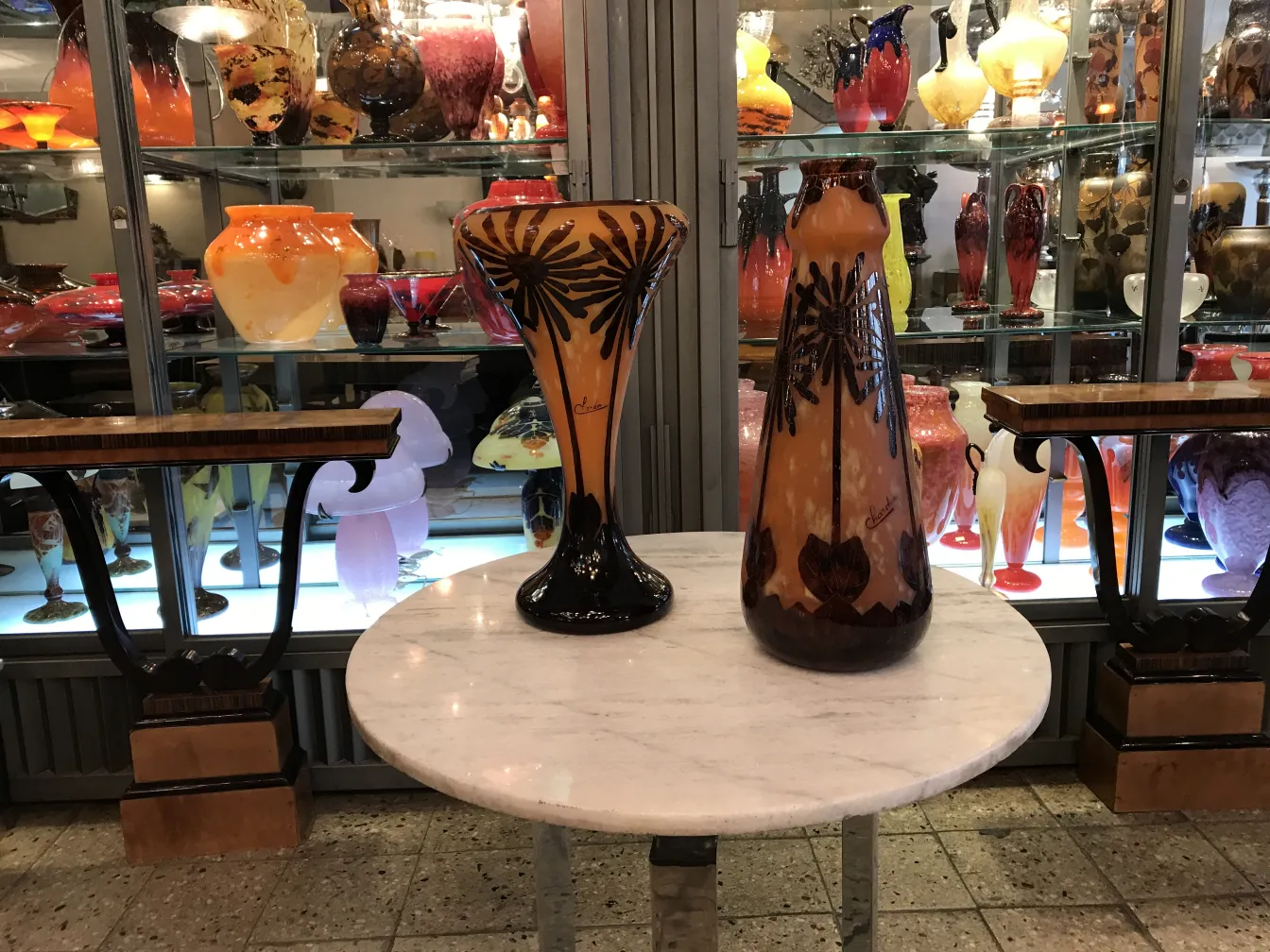 Vidro assinado Charder com design floral, antiguidade notável, fundo variado de peças de vidro.