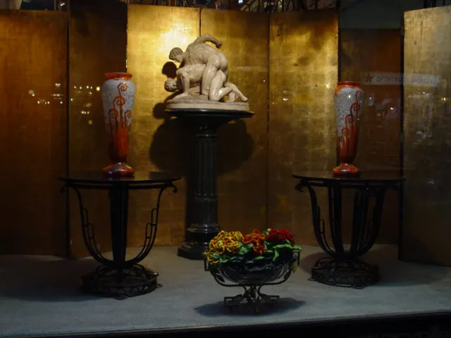 Signiertes Glas Charder in einem antiken Umfeld, mit Skulpturen und dekorativen Vasen.