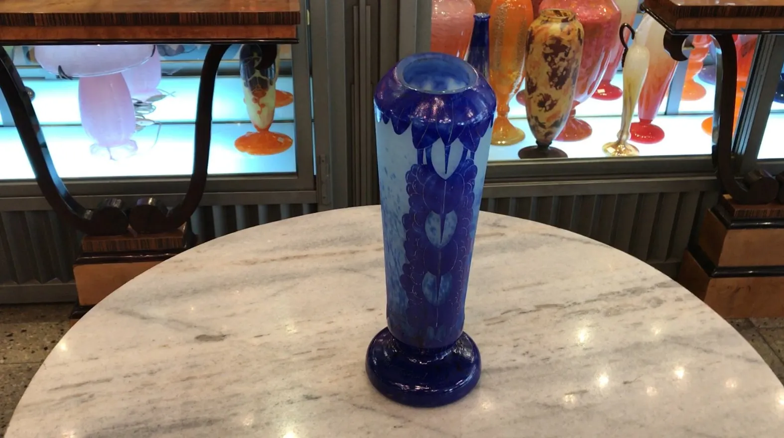 Verre signé élégant avec des détails bleus sur fond clair, dans un décor d'antiquités