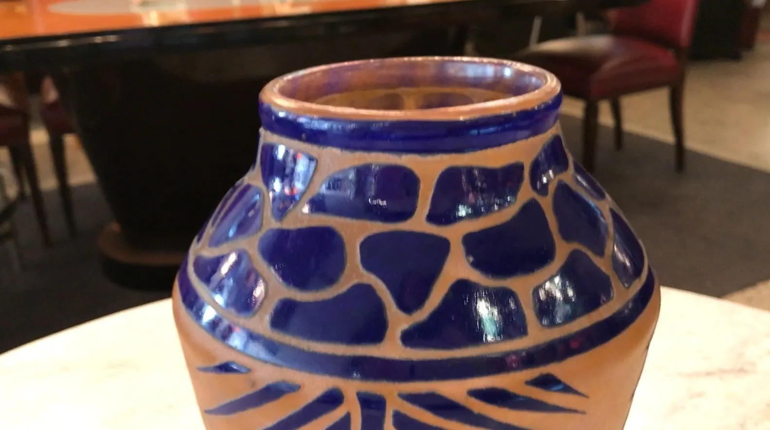 Lindo vidrio firmado Charder con diseño colorido, en un entorno vintage.