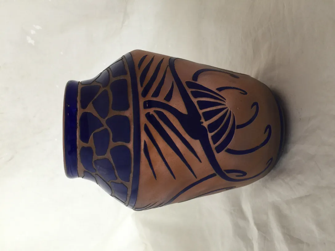 Verre ancien avec motif bleu, signé par Charder, sur fond clair.