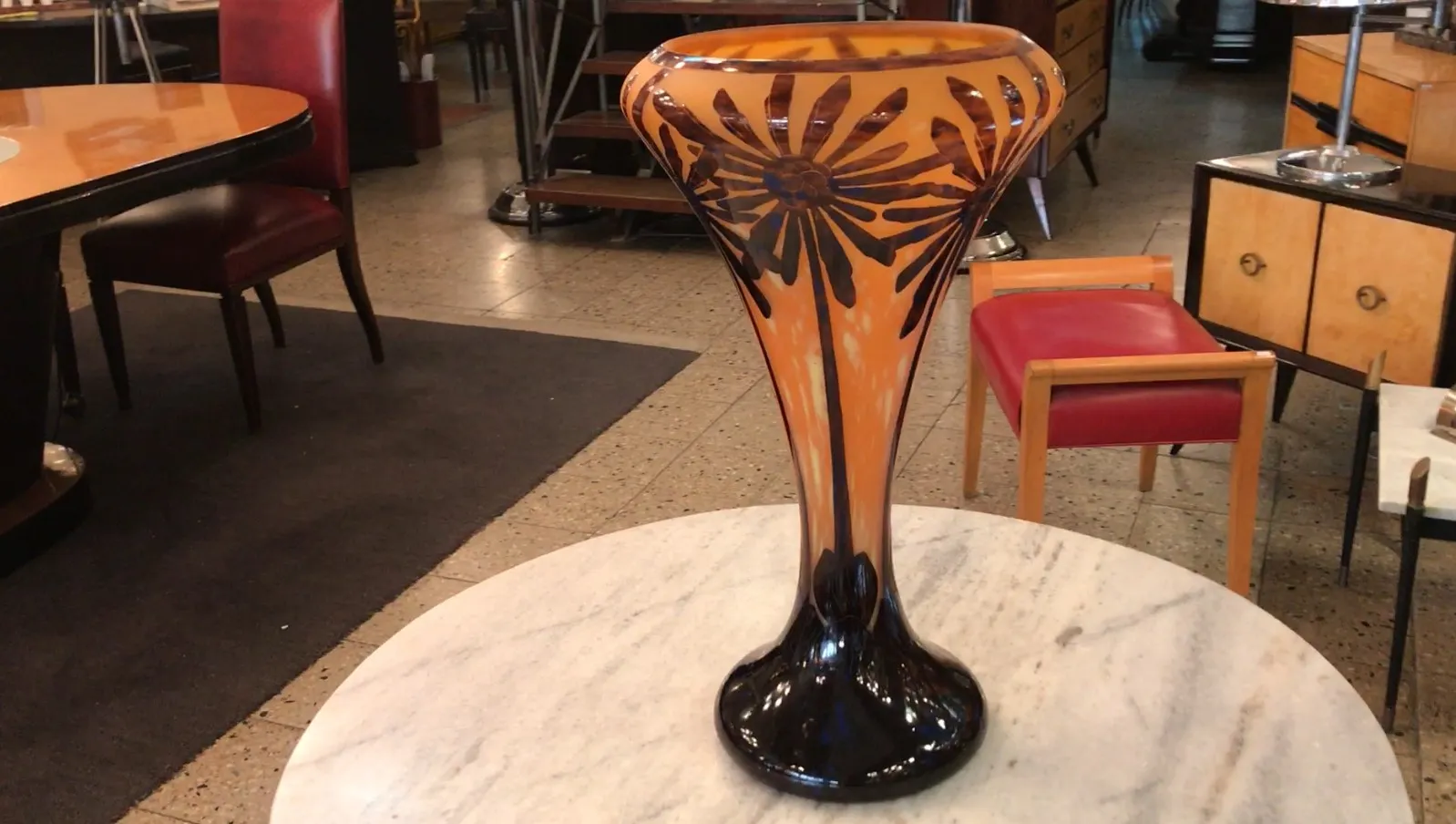 Antikes signiertes Charder-Glas mit floralen Mustern, orangefarbener Hintergrund. Moderner Kontext.