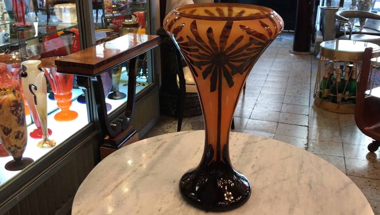 Signed glass Charder surrounded by various antique decorative items.