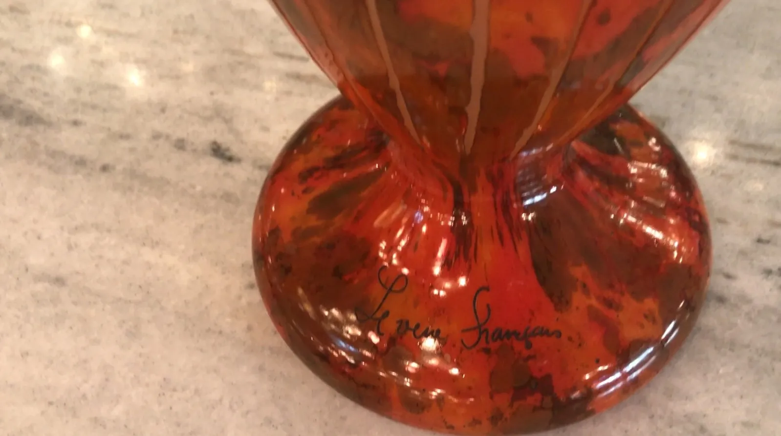 signed glass in a red shade with dark spots and shiny reflections