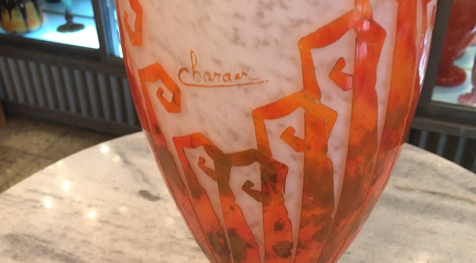 Signiertes Glas Charder mit lebhaftem orange-weißen Design.