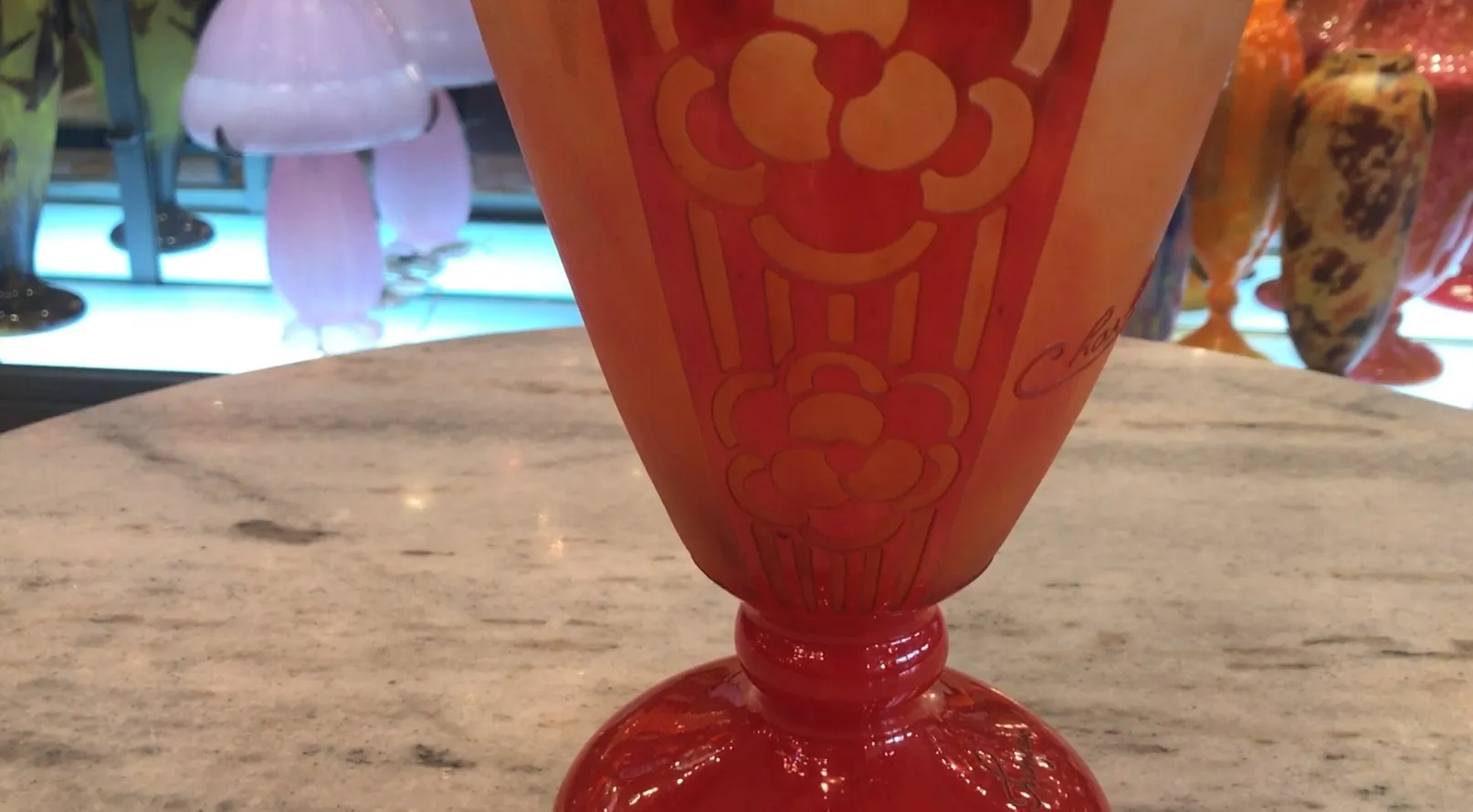 Signed glass by Charder in red and orange tones with decorative details.