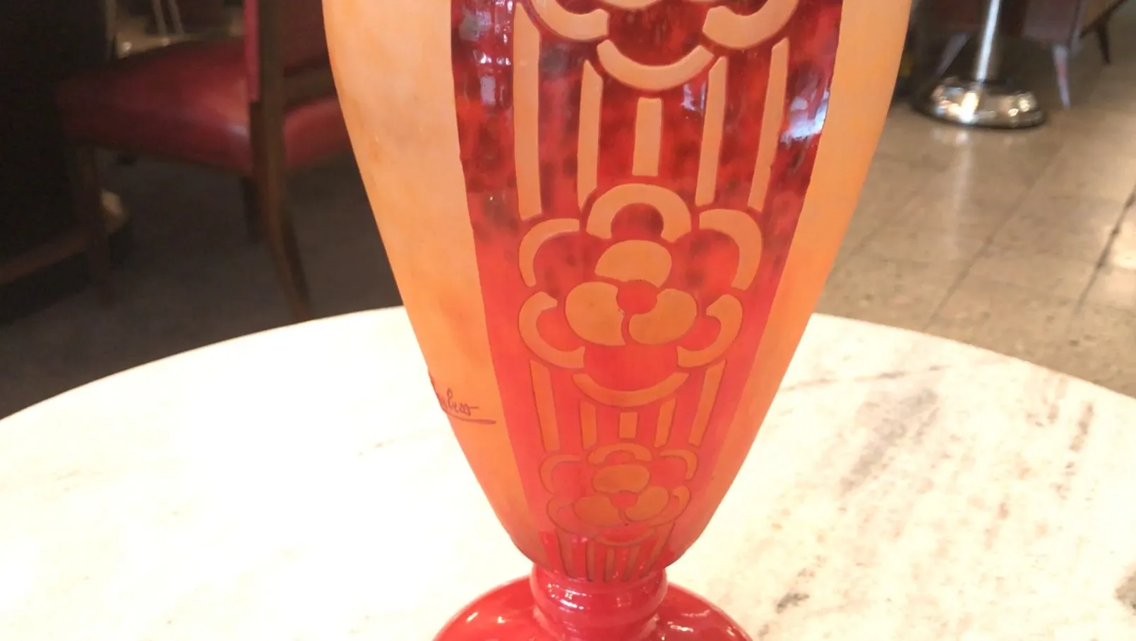 Verre antique signé de Charder avec motif floral, rouge et orange, dans un cadre chaleureux.