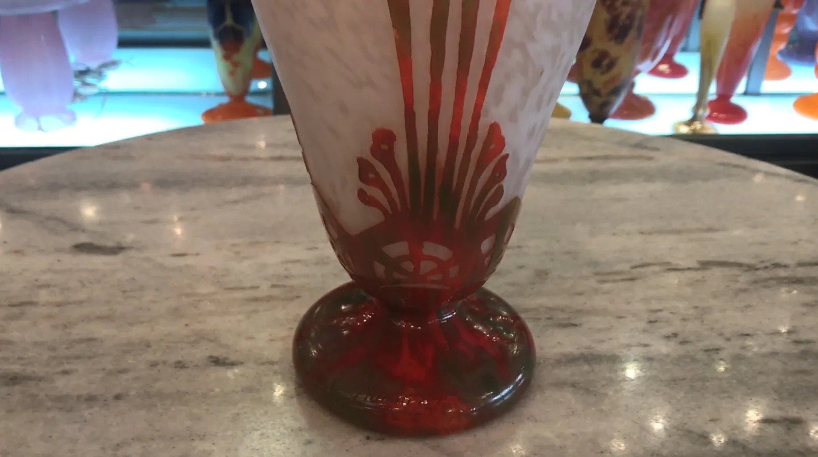 Signiertes Glas Charder elegant auf rotem Sockel präsentiert