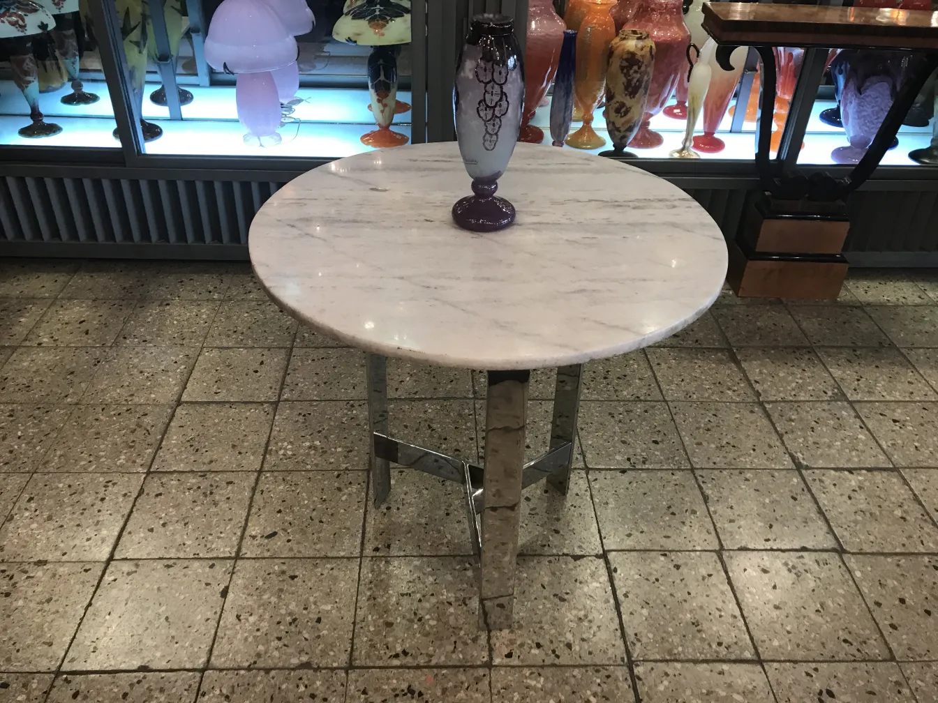 Verre signé Charder présenté dans un cadre antique avec d'autres objets décoratifs.