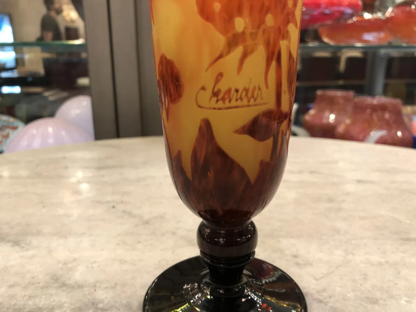 Vetro firmato con un design colorato in tonalità arancioni e marroni.