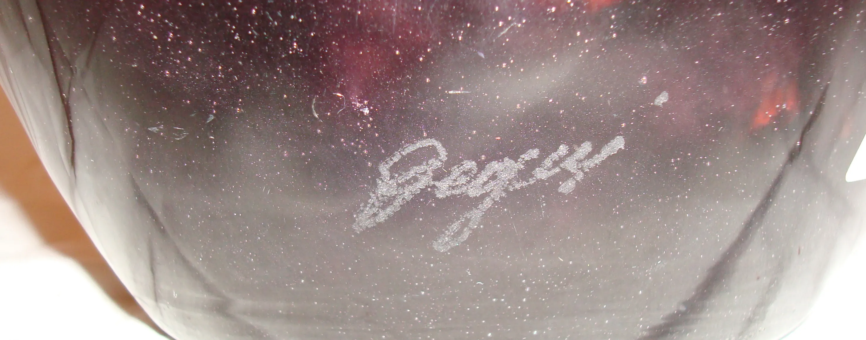 Signed antique glass showing decorative details and subtle shine.