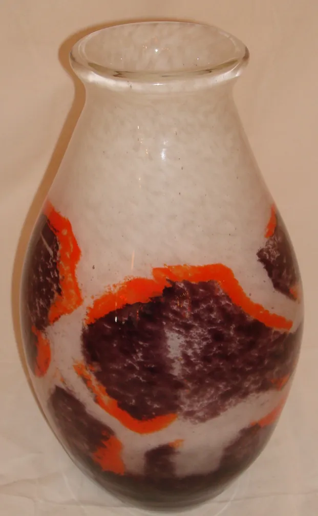 Glass vase signed by Degué, with warm-toned decorations creating visual contrast.