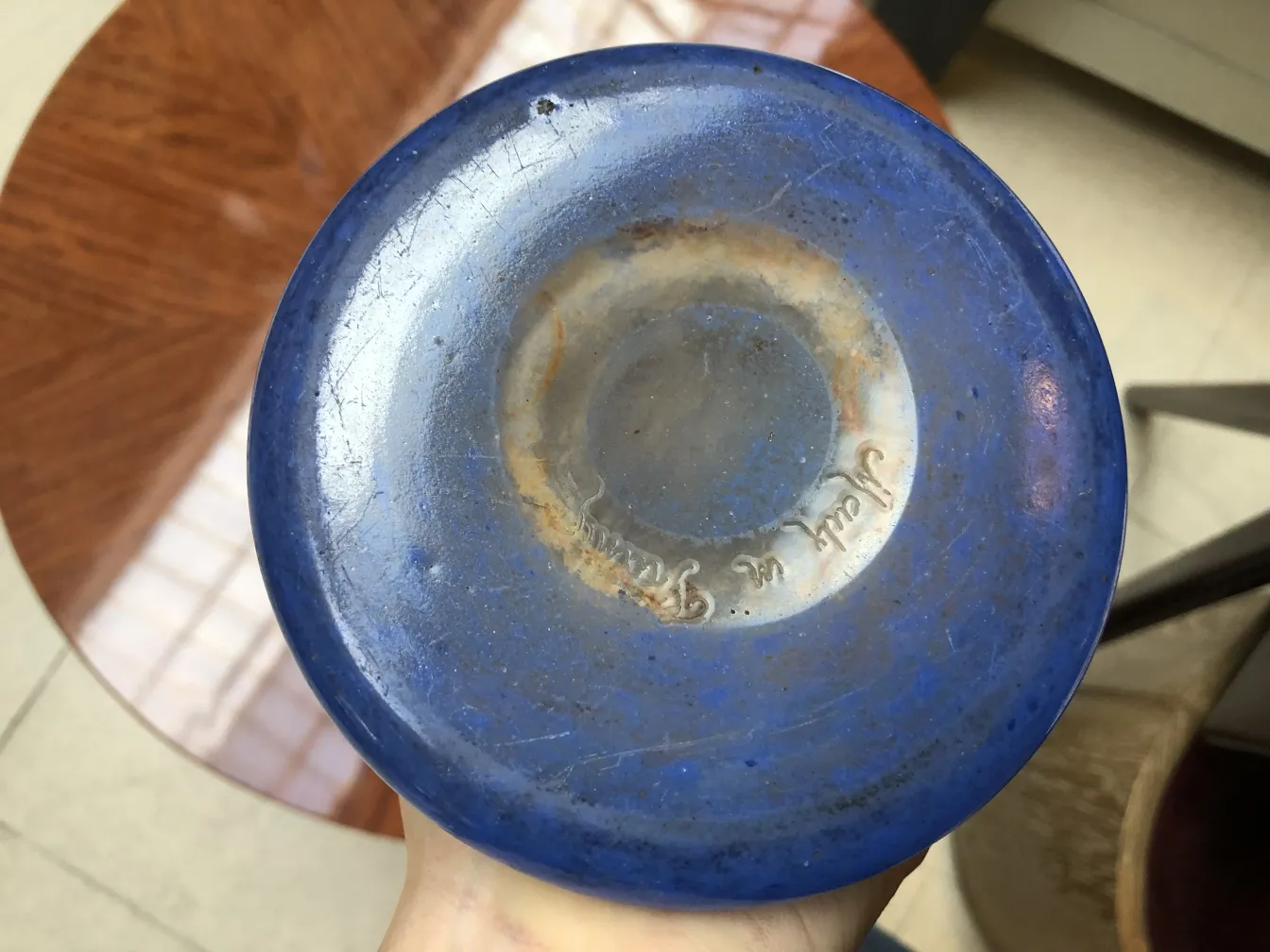 Vista de la parte inferior de un vidrio firmado Degué de color azul.