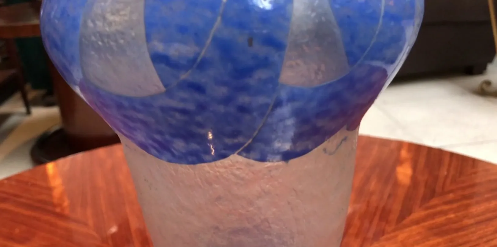 antique signed glass Degué featuring blue design and clear base on a wooden table.