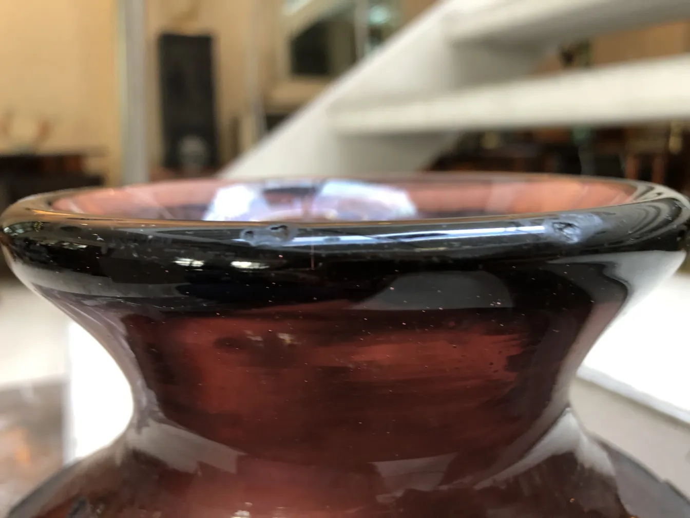 close-up of signed Degué glass with a black rim