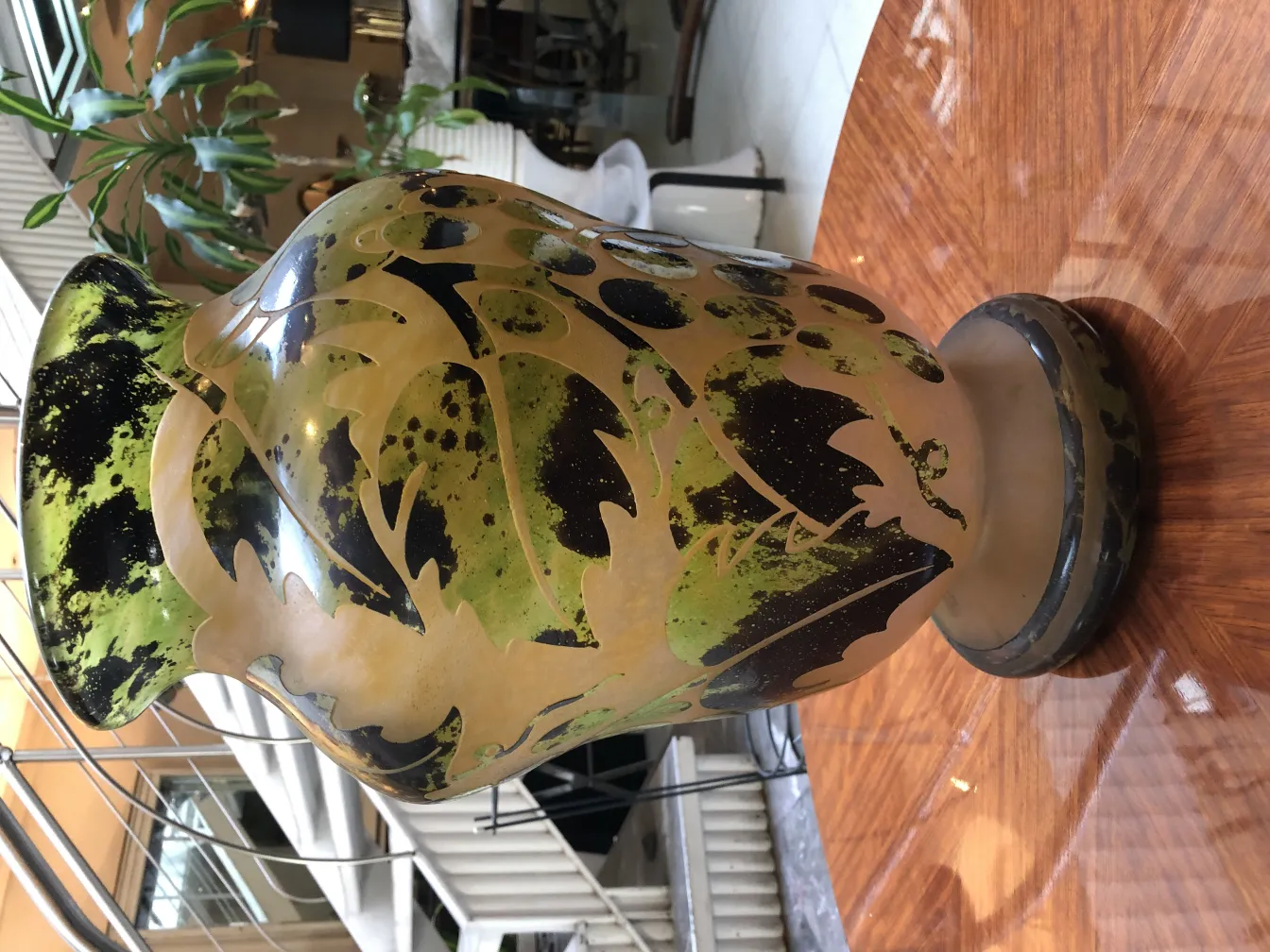 Vidro assinado Degué com decoração de folhas em um ambiente elegante.