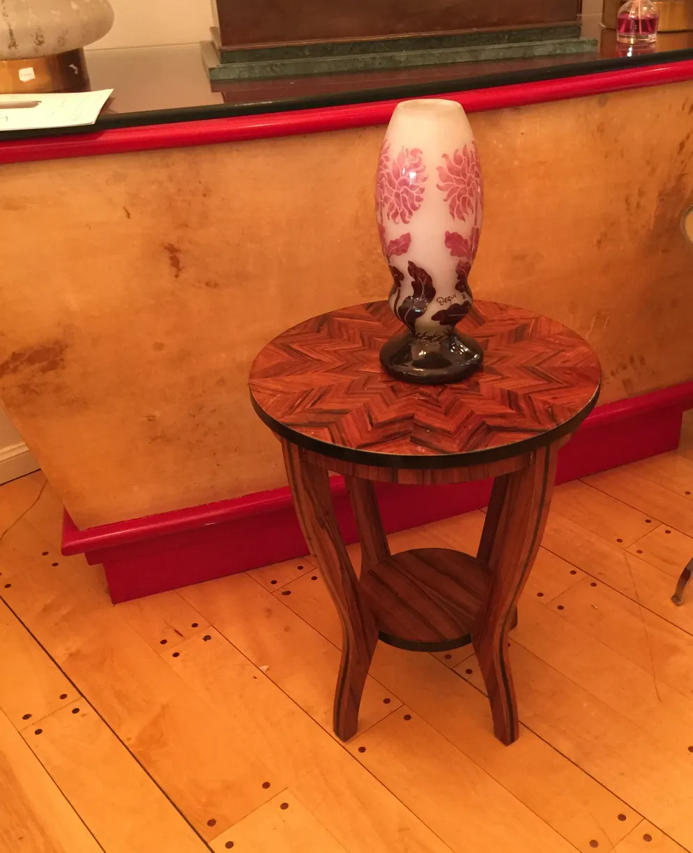 Vidro assinado Degué em uma mesa de madeira em um ambiente antigo