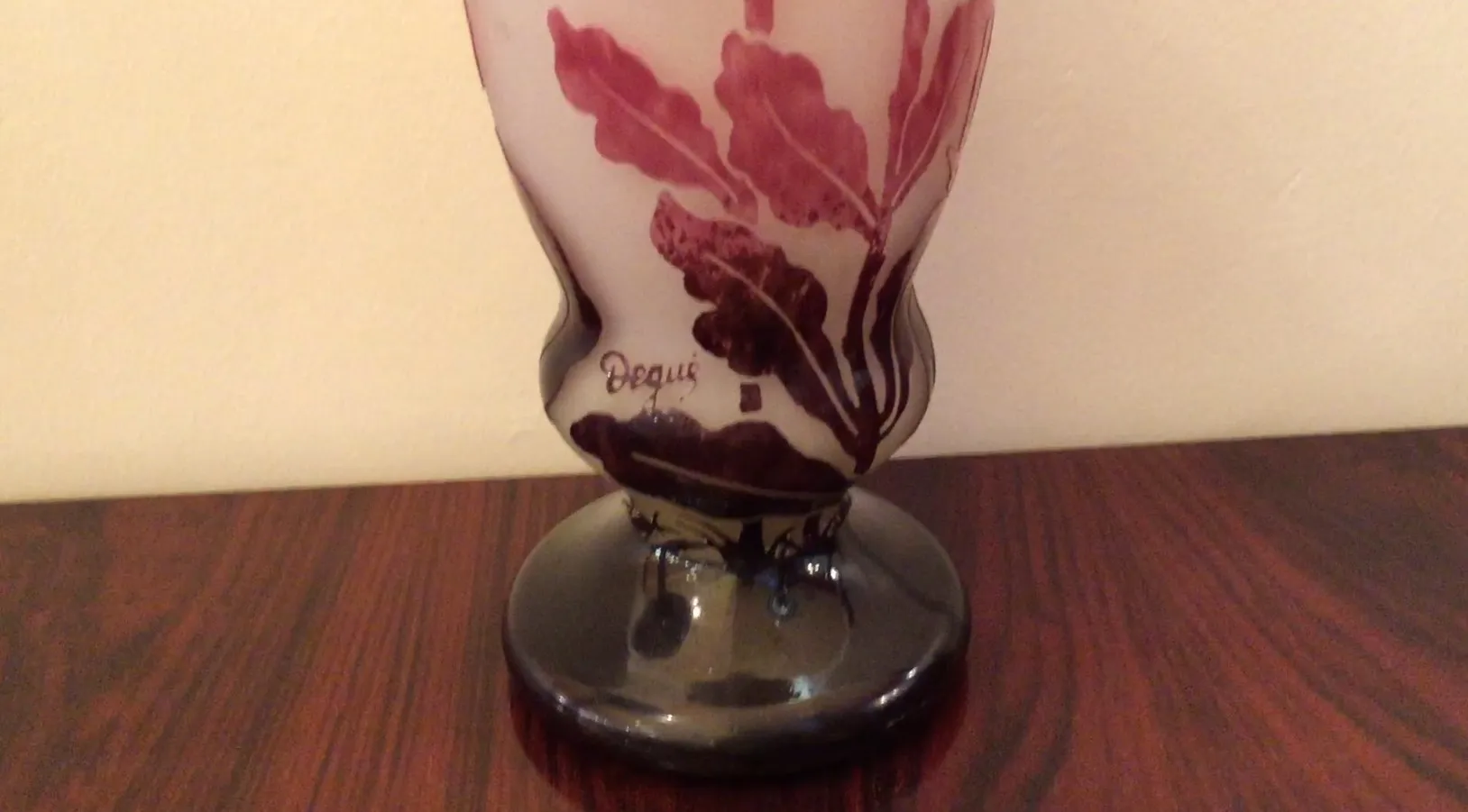 Verre ancien signé Degué avec un motif floral, base sombre.