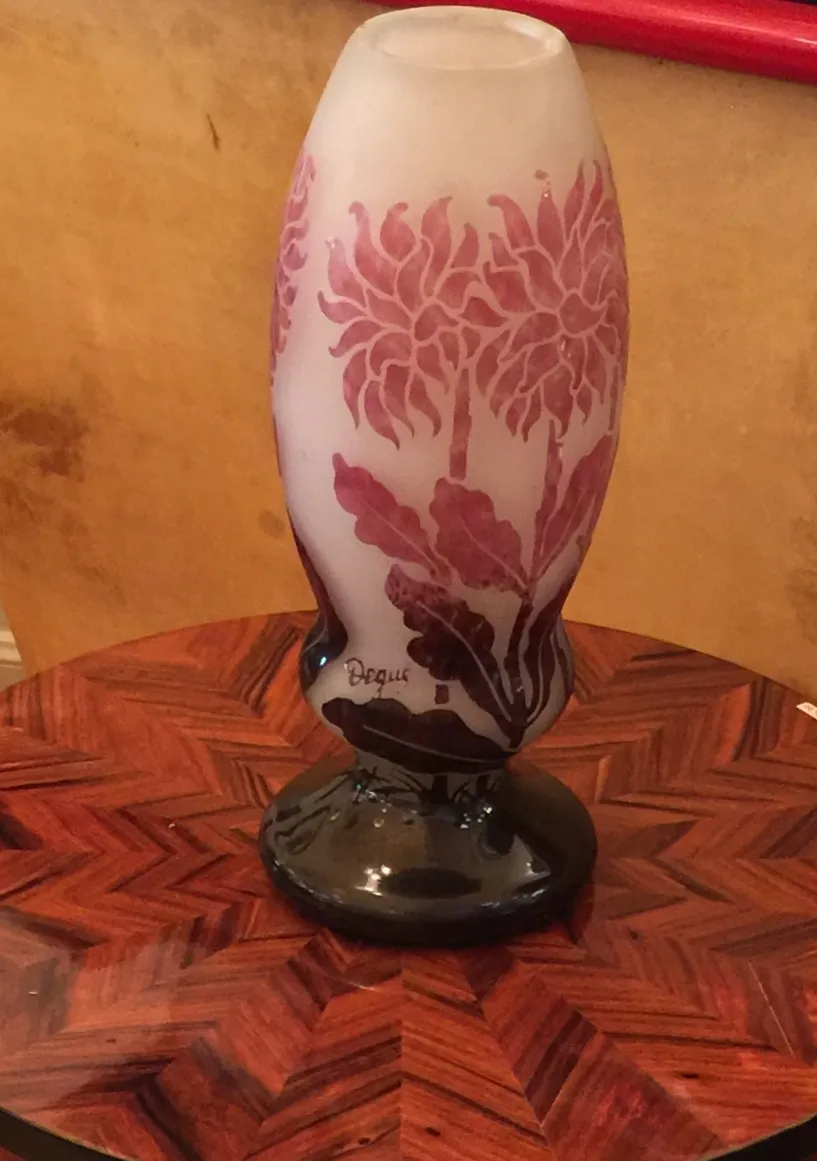 Verre signé Degué avec motif fleuri, base noire, sur table