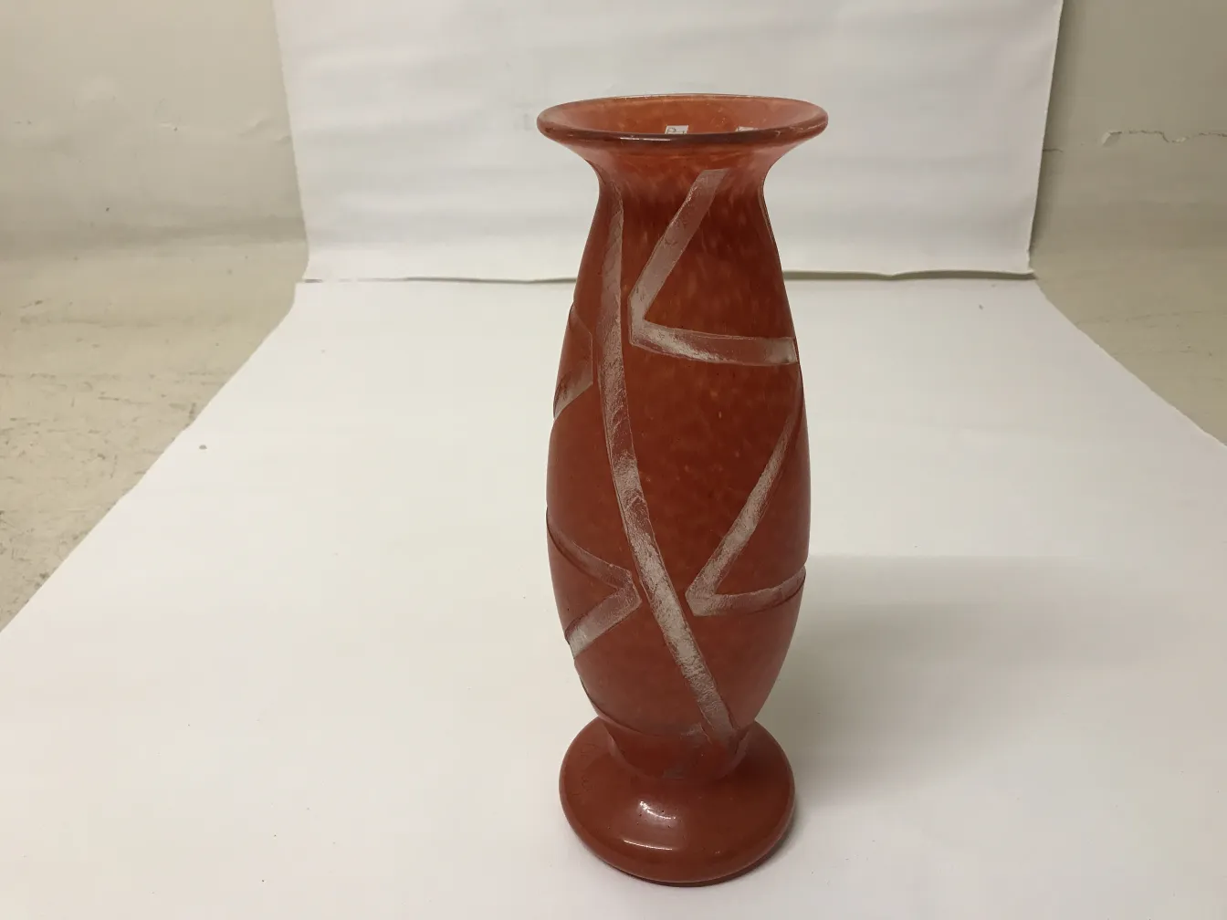 Vaso antico in tonalità terracotta con linee decorative.