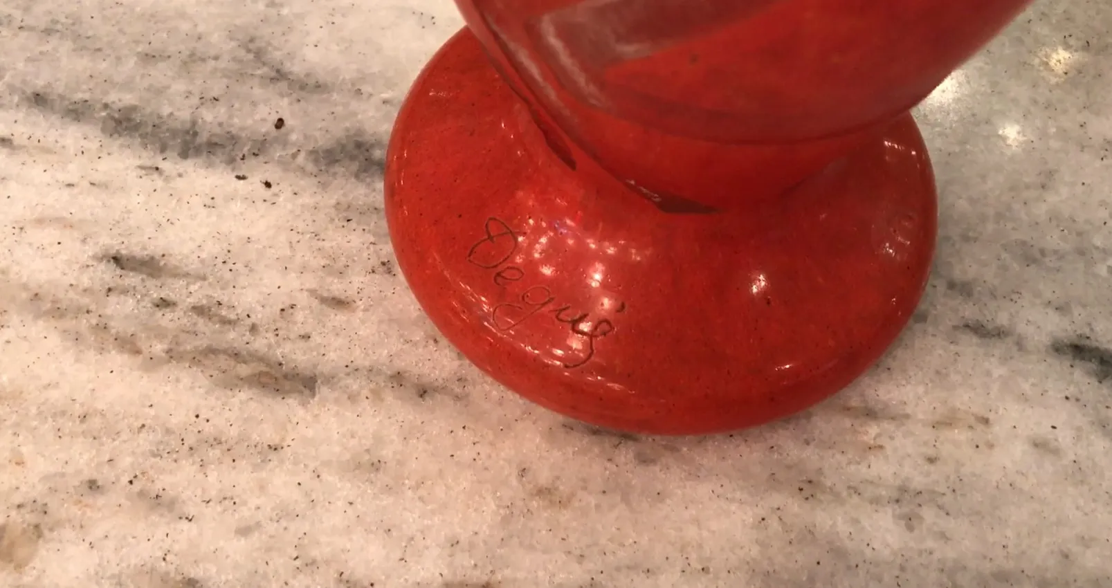 Decorative signed glass Degué in red on marble surface
