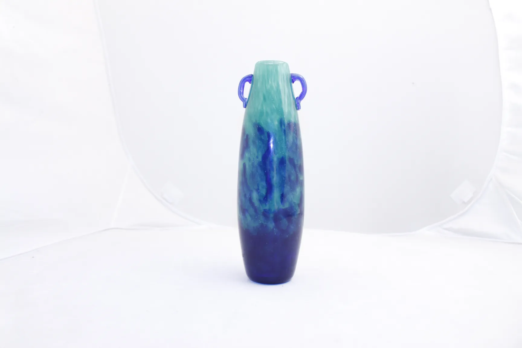 Degué signed glass vase in shades of blue and green, elegantly designed with handles, set against a white background.