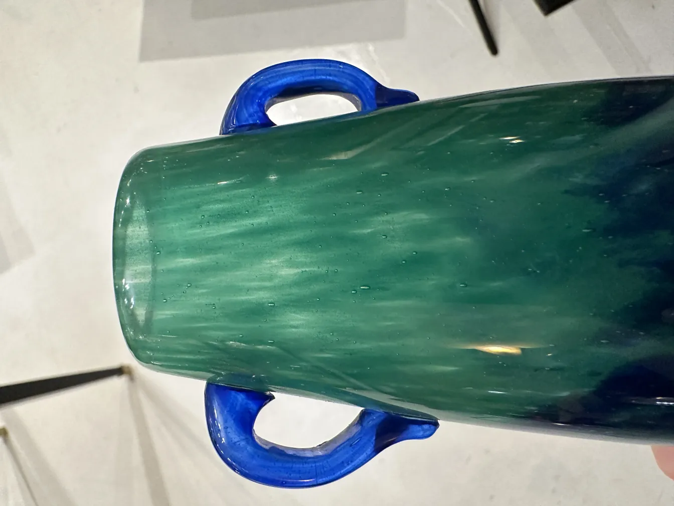 Vue de dessus d'un verre ancien signé Degué en tons bleu-vert avec poignées.
