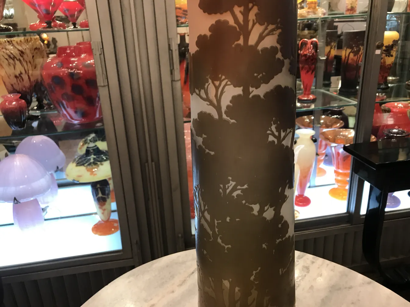 vidro assinado gallé com fundo decorativo de árvores em um ambiente antigo