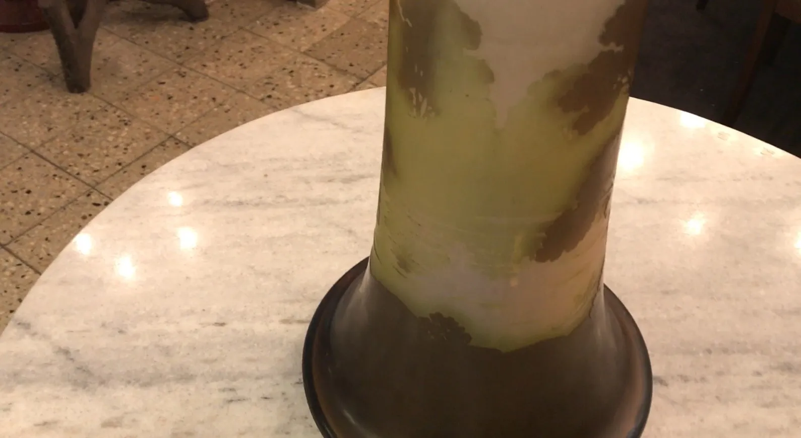 antikes signiertes Glas Gallé mit grünen und braunen Details auf einem hellen Tisch