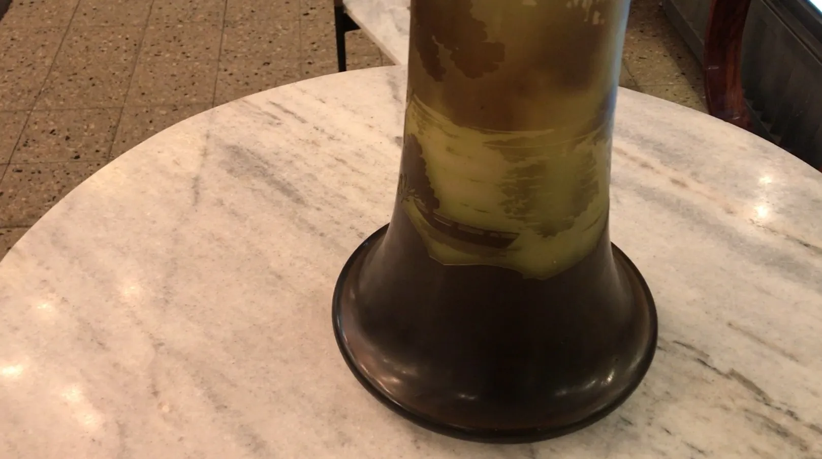 Vidrio antiguo firmado Gallé con un paisaje visible en la superficie.