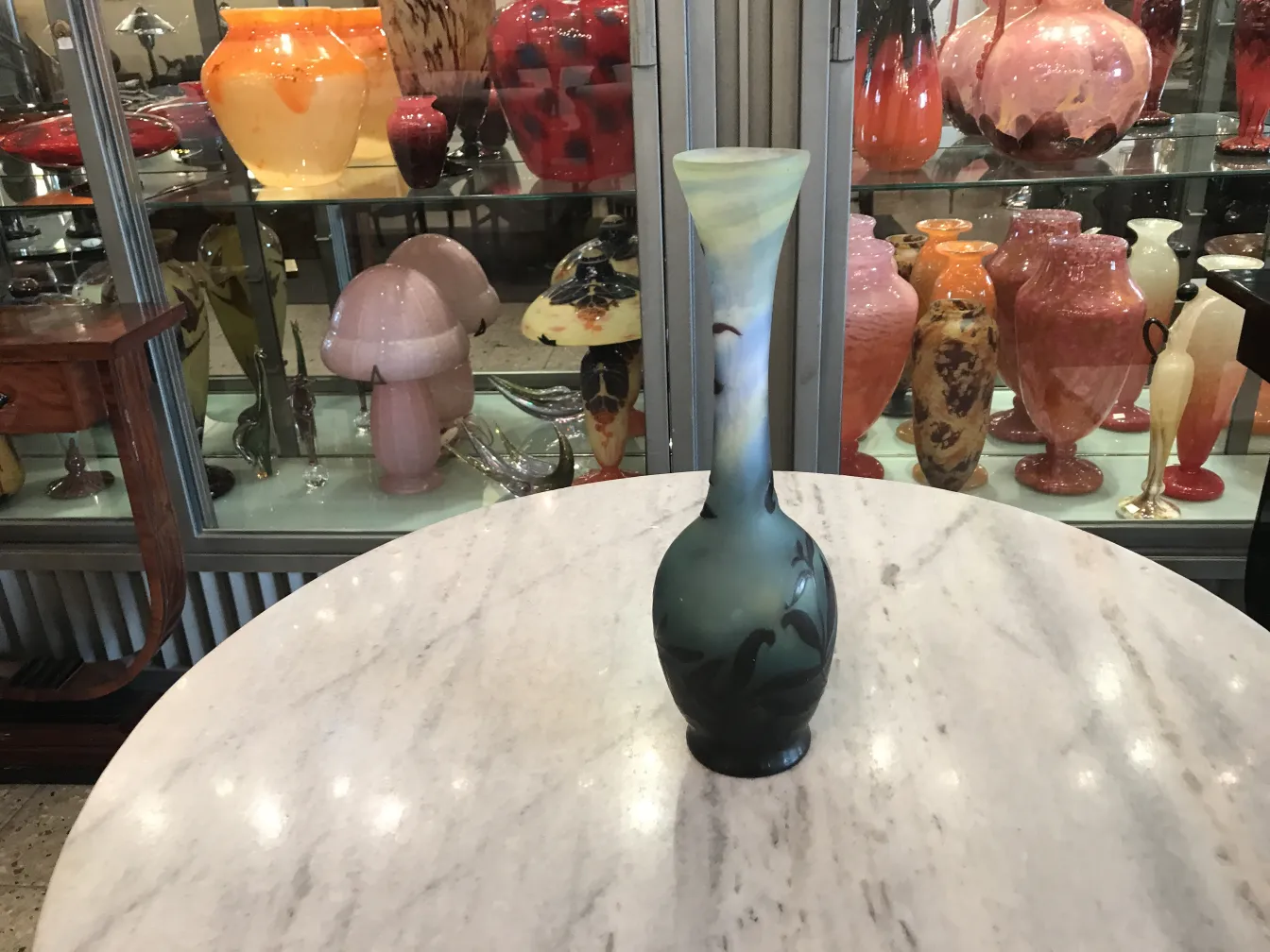 Antike mit Design aus signiertem Glas Gallé, dekorativ auf einem Tisch mit anderen Glasgegenständen im Hintergrund.