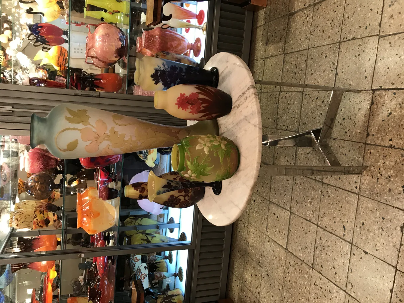 Vaso antigo de vidro assinado Gallé, com decoração floral e paleta de cores variada.