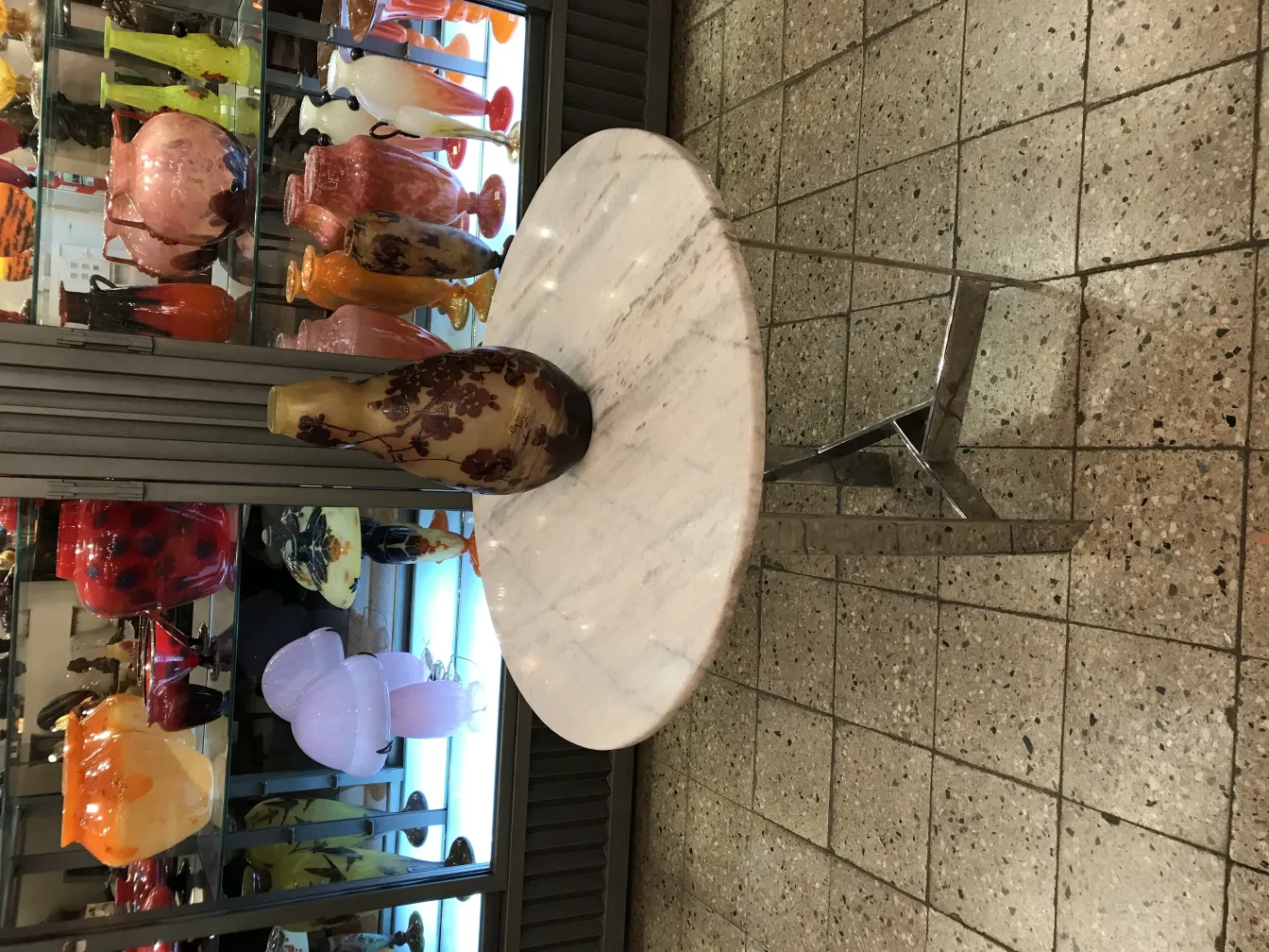 Vase firmado Gallé en un entorno de antigüedades variadas.