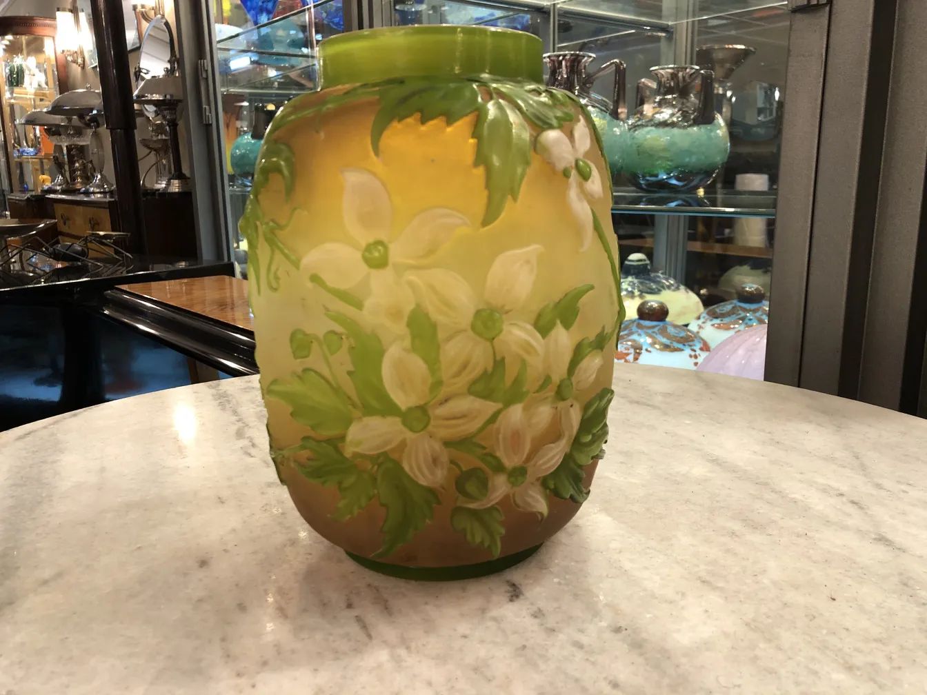 verre signé Gallé ancien avec des fleurs blanches et vertes, entouré d'antiquités