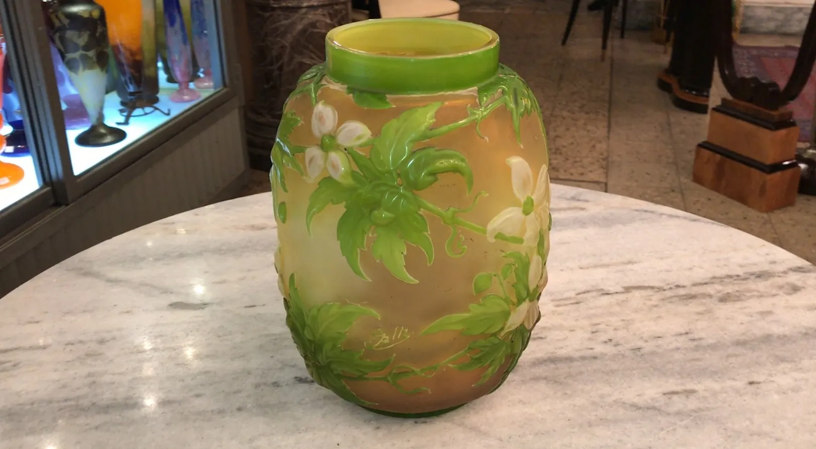 Signiertes Glas Gallé mit buntem Blumendesign auf hellem Hintergrund, in einer antiken Umgebung.