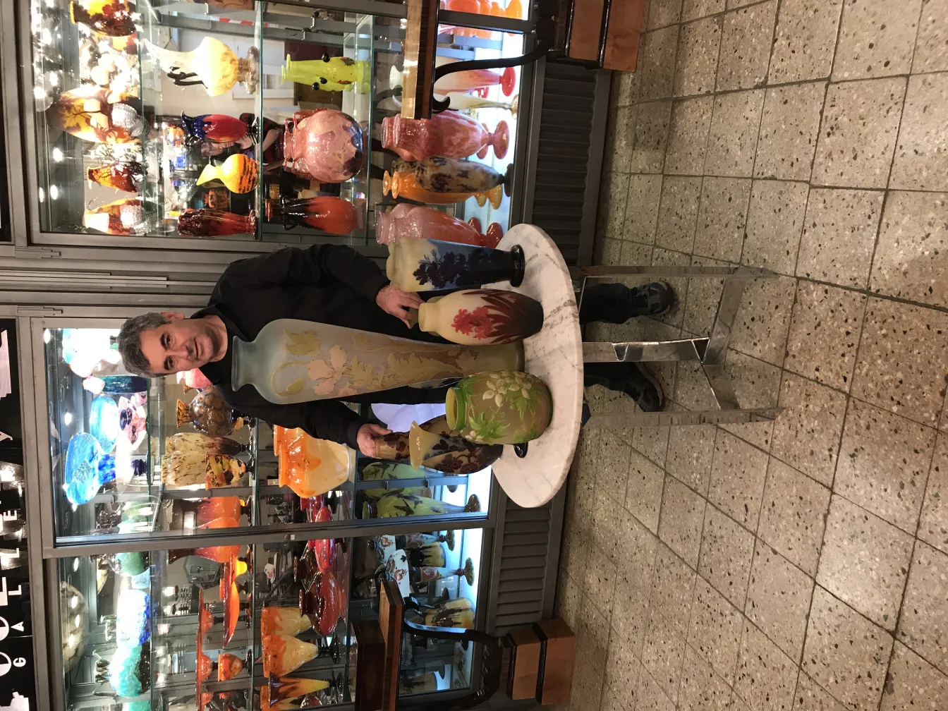 Vasos de vidro antigos em exibição, alguns com desenhos florais.