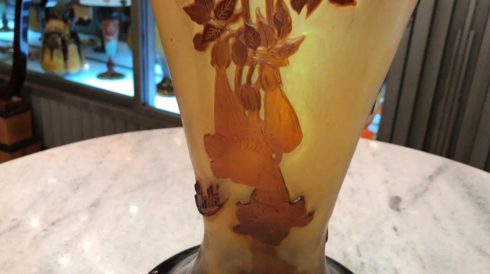 Verre signé Gallé avec des motifs floraux en tons dorés et bruns sur fond clair, faisant partie d'une collection d'antiquités.