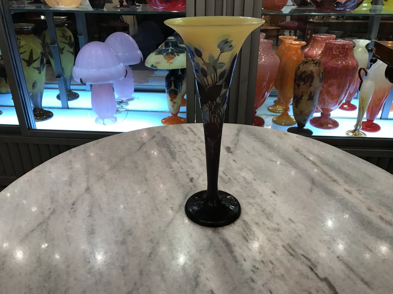 Signiertes Glas Gallé vor einem Hintergrund aus bunten Antiquitäten